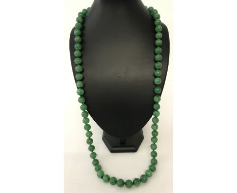 A 34" apple green jade, beaded necklace; knotted between each bead.  Beads approx. 1.25cm diameter.