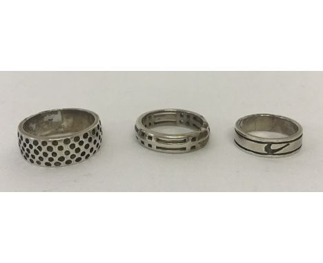 3 silver and white metal band style rings. A Celtic design, a band with circle decoration and empty cartouche and a band with