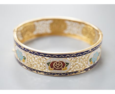 A pierced yellow metal and polychrome enamel set hinged bangle, gross weight 25.3 grams, (enamel a.f.).