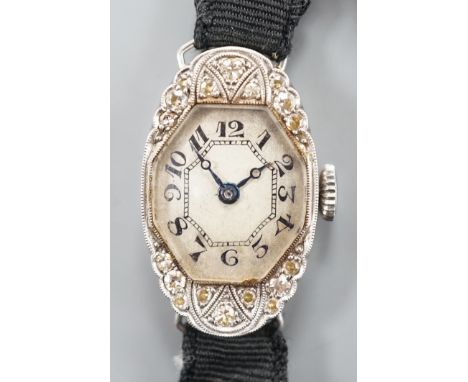 A lady's white metal (stamped platine) and diamond set oval cocktail watch, on a black sash bracelet, gross weight 13.9 grams