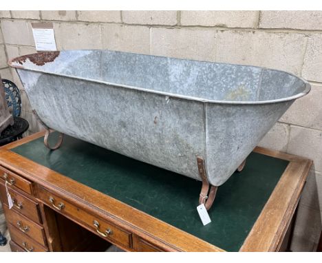A vintage galvanised trough on wrought iron feet, length 146cm, depth 62cm, height 49cm