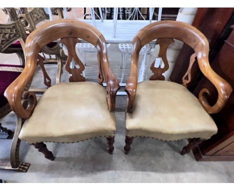 A pair of Victorian walnut elbow chairs with light brown leather seats, width 59cm, depth 51cm, height 90cm