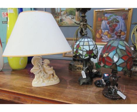 Two similar small modern Tiffany design table lamps, together with another table lamp, the base modelled as a cherub on natur