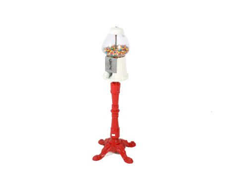 A vintage 'gumball' sweet dispenser. Having a glass top, mounted on a cast metal stamp, painted in white and red, on a tripod