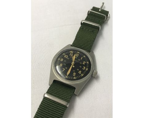 Vietnam War style US Army wristwatch with green canvas strap. Wind up mechanism in working order; with luminescent hands, num