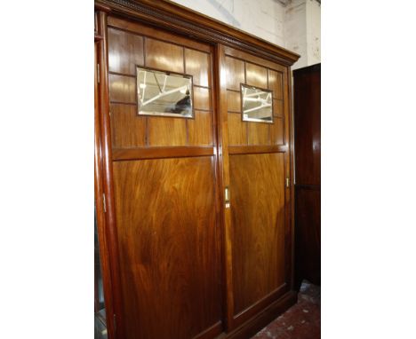 A late Victorian mahogany estate cupboard, circa 1890, the moulded cornice above a pair of sliding doors decorated with mould