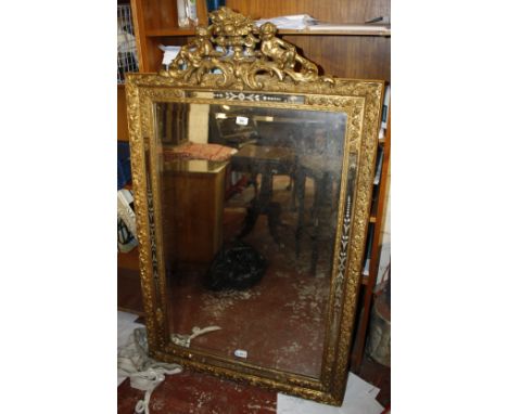 A Continental giltwood wall mirror, 19th century, possibly Venetian, surmounted by cherubs and floral vase above rectangular 