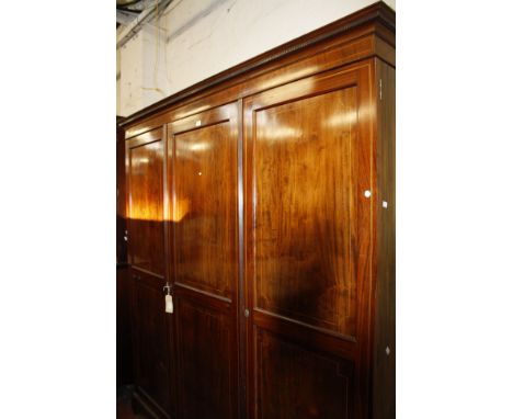A mahogany and inlaid triple wardrobe with a single and double cupboard enclosing hanging space on bracket feet 190cm wide 