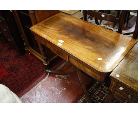 A Regency mahogany card table, circa 1815, the cross-banded top opening and revolving to baize playing surface and concealed 