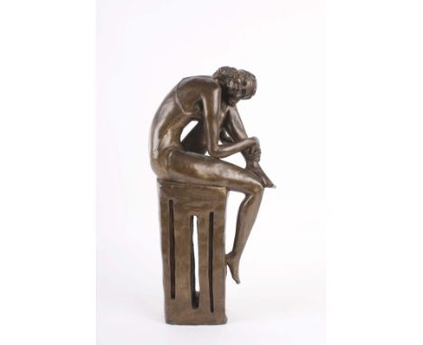 A 20th Century bronzed sculpture of a young woman sat on a plinth, monogrammed to base K N no.6/9, 42cm high