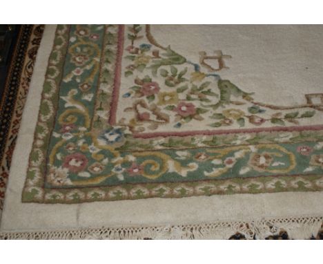 20th century large Indian bordered carpet in shades of green with pink coloured flowers on an off white ground 361 x 274 cm
