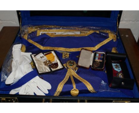 Case containing Freemason's apron, sash, two steward medals 1975 & 1987, 9 ct gold Masonic Jewel and presentation silver and 