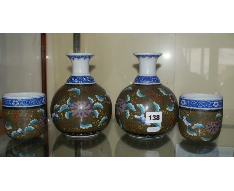 A pair of Oriental ceramic caraffes and tumblers to match with blue and white rims, cloisonné decoration on the bodies depict
