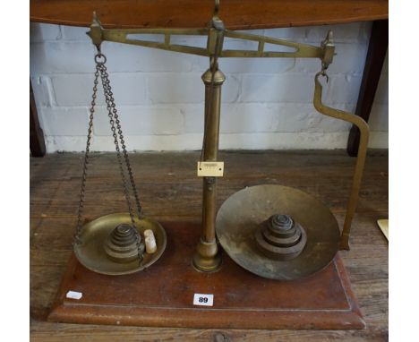Set of late 19th early 20th century brass chemist's balance scales with two sets of graduated weights on a mahogany base