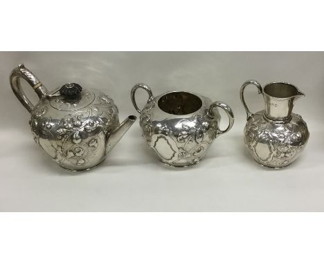 A fine quality Victorian silver three piece bachelor's tea service attractively decorated with flowers and leaves. London. By