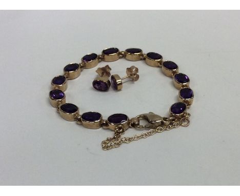 A 9 carat amethyst bracelet with safety chain together with matching earrings. Approx. 18 grams. Est. £100 - £200.