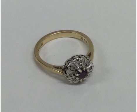 A ruby and diamond circular cluster ring in 18 carat gold. Approx. 3 grams. Est. £50 - £80.