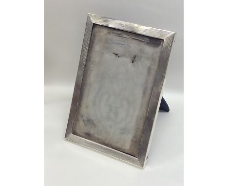 A rectangular engine turned silver picture frame of typical form. Approx. 20 cms x 14 cms. Est. £70 - £80.