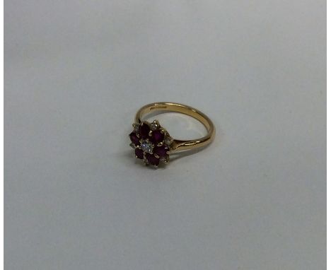 An attractive ruby and diamond daisy head cluster ring in 18 carat gold claw mount. Approx. 4.5 grams. Est. £300 - £400.