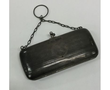 An Edwardian silver engine turned purse with suspension chain. Birmingham. By FD. Approx. 65 grams. Est. £25 - £35.