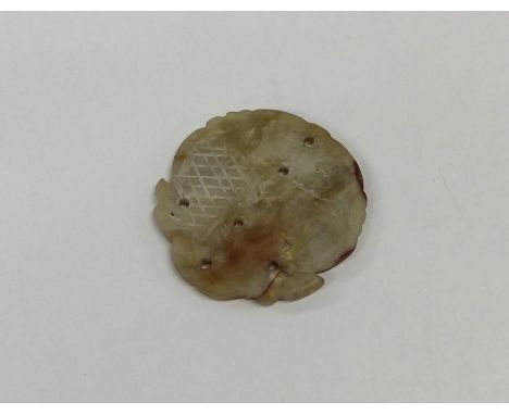 A carved jade circular disc. Approx. 17 grams. Est. £15 - £20.
