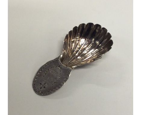 A Georgian silver bright cut caddy spoon with fluted bowl. London. By RC. Approx. 9 grams. Est. £10 - £20.