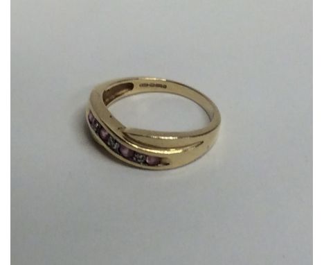 A pink sapphire and diamond ring in 9 carat mount. Approx. 3 grams. Est. £40 - £60.