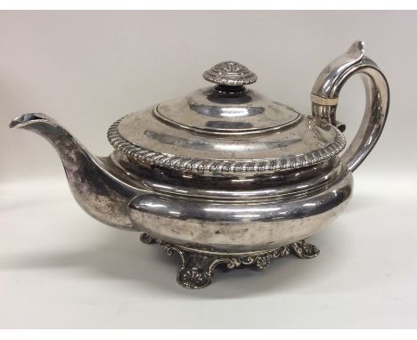 A good quality circular Georgian silver teapot with gadroon rim and crested armorial. London. By Eames &amp; Barnards. Approx
