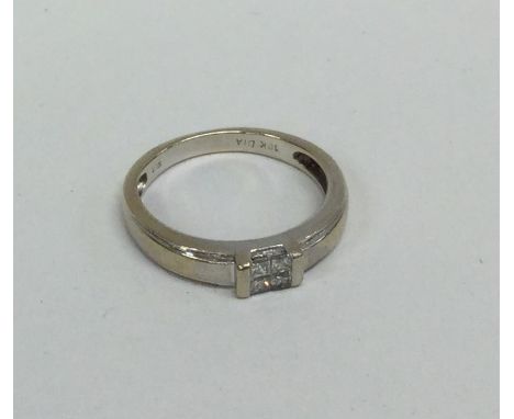 A diamond four stone princess cut ring. Approx. 3 grams. Est. £85 - £95.