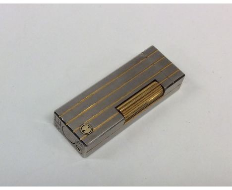 DUNHILL: A stainless steel and gold mounted lighter with hinged top. Approx. 78 grams. Est. £30 - £40.