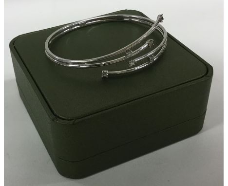 A 9 carat stone set torque bangle contained within a fitted box. Approx. 10 grams. Est. £100 - £150.