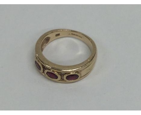 A ruby three stone ring. Approx. 4 grams. Est. £40 - £60.