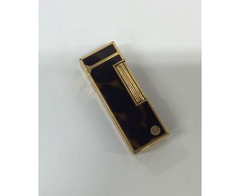 DUNHILL: A gilt and tortoiseshell effect lighter with hinged top. Approx. 71 grams. Est. £30 - £40.