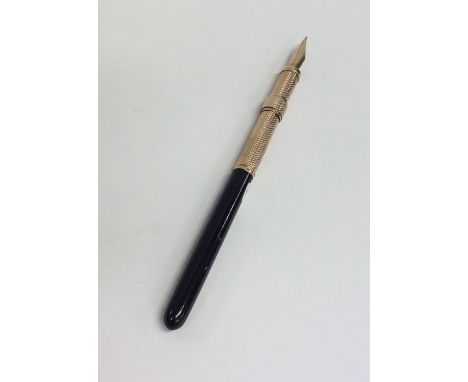 A small gold engine turned quill. Approx. 17 grams. Est. £30 - £40.