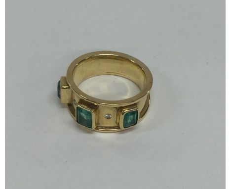 An emerald and diamond tapering ring in 18 carat gold. Approx. 10 grams. Est. £150 - £250.