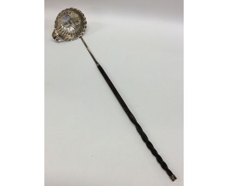 A good Georgian silver toddy ladle with swirl bowl and pouring lip to whalebone handle. Approx. 30 grams. Est. £20 - £30.