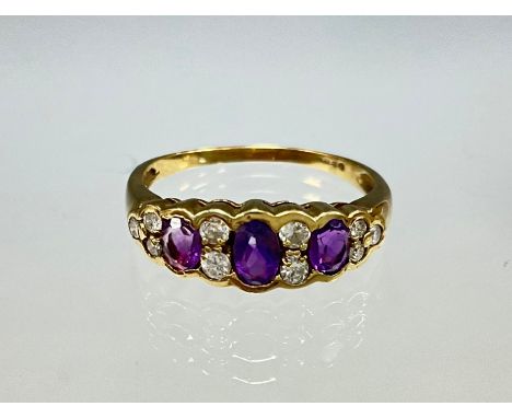 A 9ct Gold Amethyst and Diamond Ring;set with three oval brilliant cut amethysts, the centre one measuring approx. 4mm x 3mm,