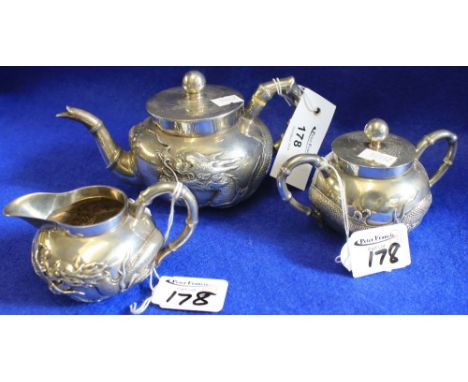 Chinese white metal, dragon design, three piece tea set comprising: teapot, sugar bowl and cover and cream jug, mark to base: