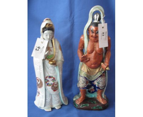 A Japanese painted ceramic figure of a standing fierce immortal, together with another Japanese standing figure of a woman. (