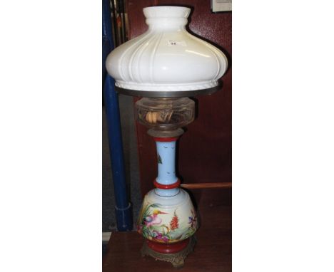Unusual brass double burner oil lamp having clear glass faceted reservoir and clear glass chimney on a ceramic pedestal base,