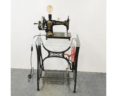 A Jones cast iron treadle sewing machine converted to a table with plate glass top together with a table lamp converted from 