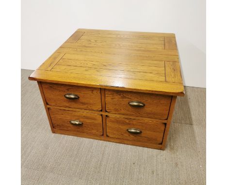 A four drawer light oak coffee table with back storage, 75 x 75 x 44cm.