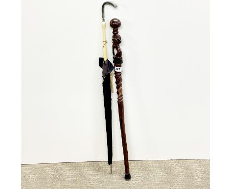 An African carved hardwood walking stick, L. 80cm. Together with a vintage lady's umbrella.
