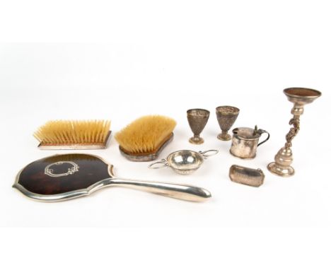 TWO SILVER BACKED BRUSHES, a silver and tortoise shell backed mirror, 29cm in length; a white metal candlestick marked 830; a