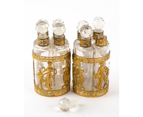 A PAIR OF 19TH CENTURY CONTINENTAL EMPIRE STYLE GILT ORMOLU MOUNTED SETS OF FOUR SCENT BOTTLES each with gilt pierced collars