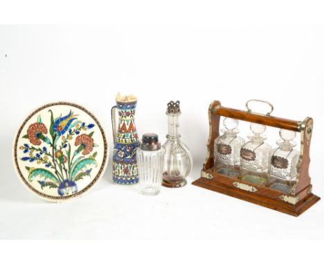 A VICTORIAN OAK AND SILVER PLATE TANTALUS with three cut glass bottles and three silver spirit labels 'Sherry', 'Brandy' and 