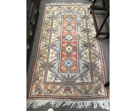 A 20th Century wool floor rug decorated in pastel colours with a geometric design