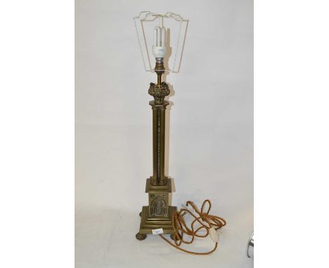 A 19th Century brass oil lamp, with architectural decoration to base raised on four shaped feet, 55cm igh