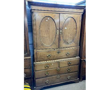 A Georgian oak cupboard with moulded cornice over two panelled doors opening to a shelved interior over a further drawer, the