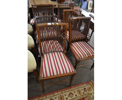 A set of four Edwardian mahogany dining chairs with stick backs and striped upholstered seats together with two similar armch